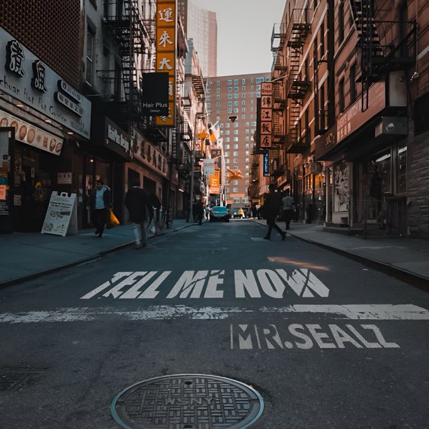 Cover art: Tell Me Now — a Chinatown street with the title painted on the road.